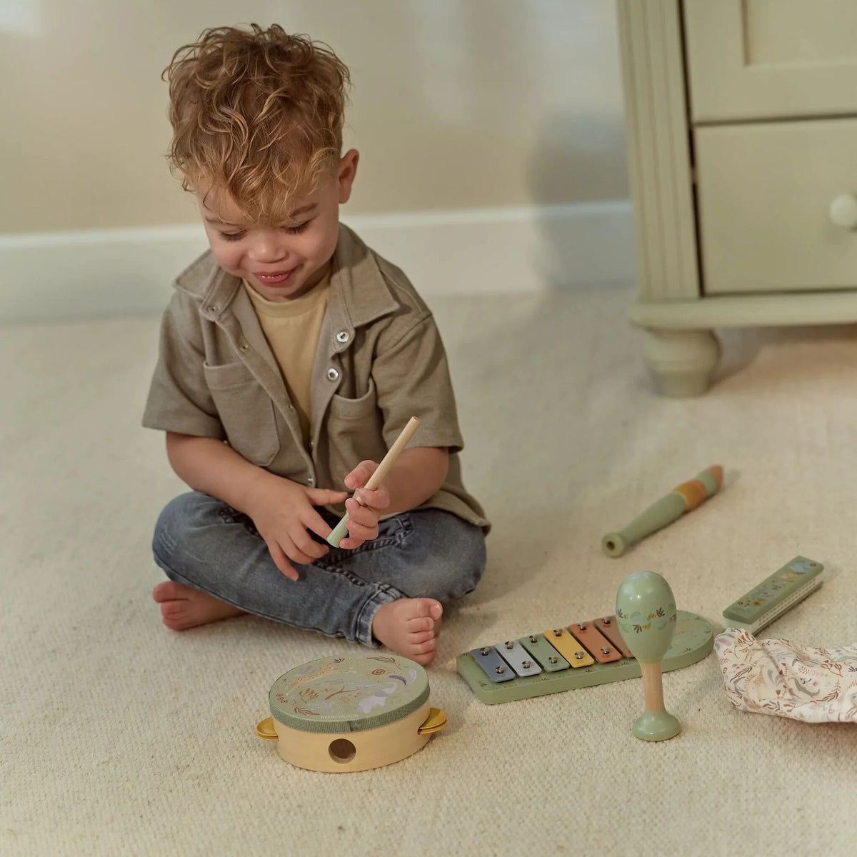 Child playing with the Little Dutch Safari Friends Music Set Green