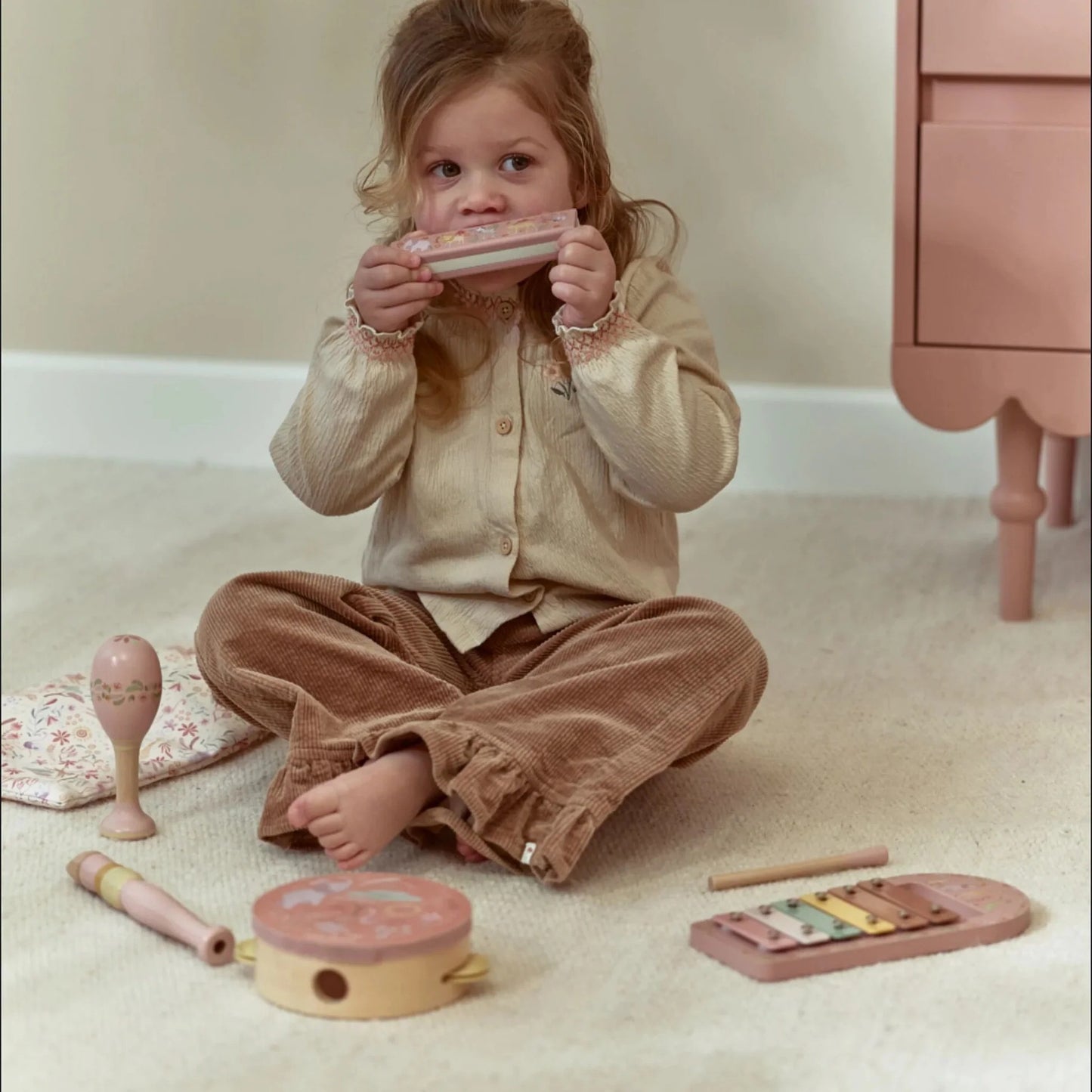 Child playing the harmonica from the Little Dutch Safari Friends Music Set Pink