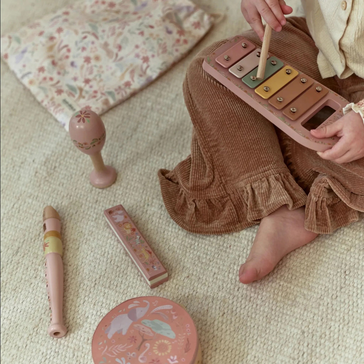 Child playing the Little Dutch Safari Friends Music Set Pink xylophone