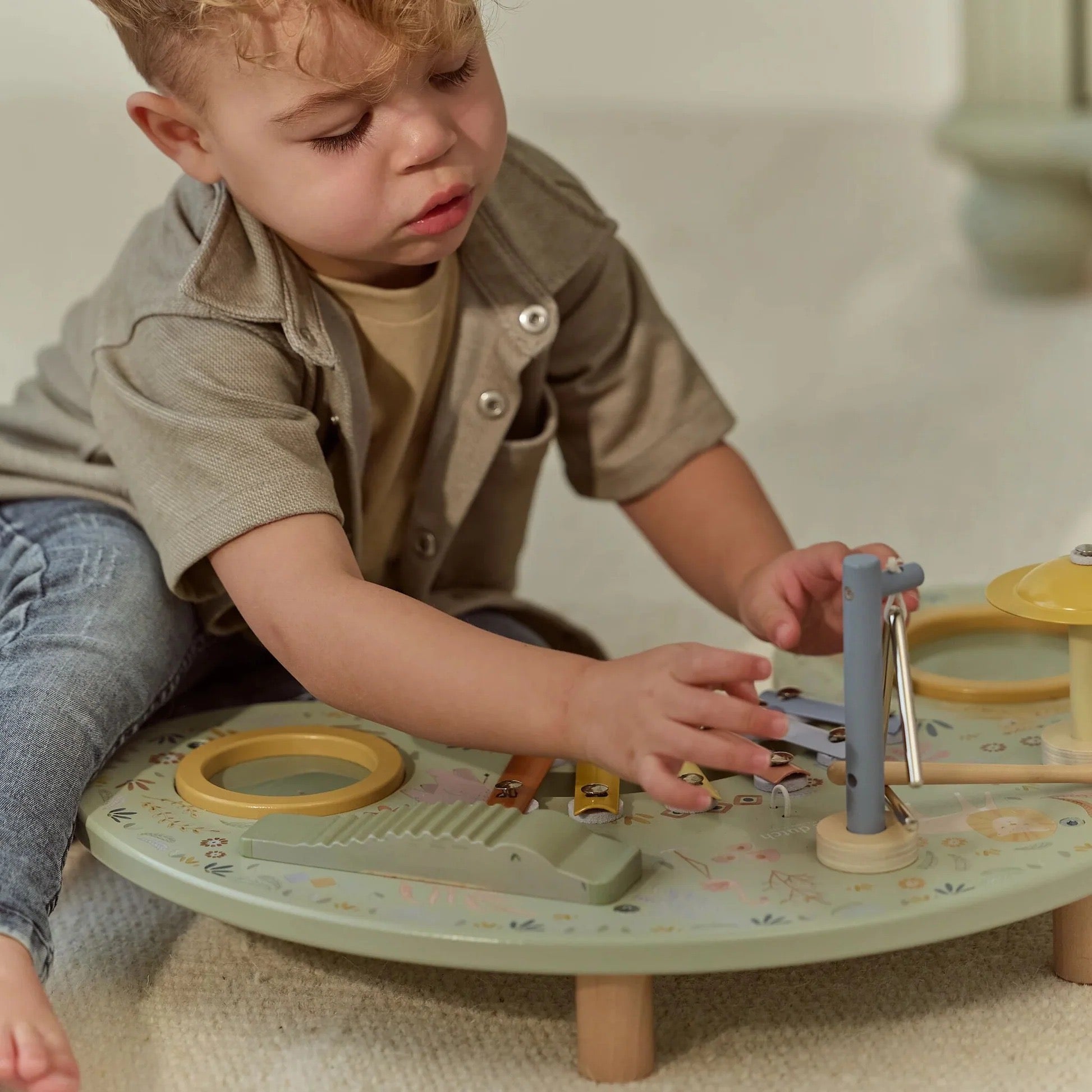 Child exploring instruments on the Little Dutch Safari Friends Music Table
